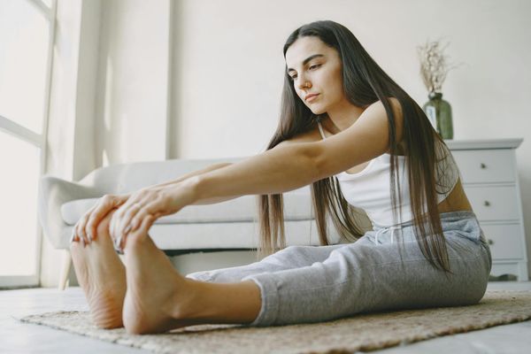 Woman performing a focused yoga sequence in a bright room.
